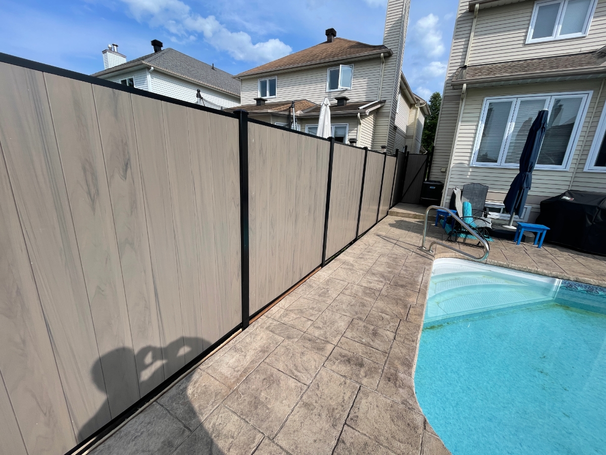 Fence with black trim in backyard with pool