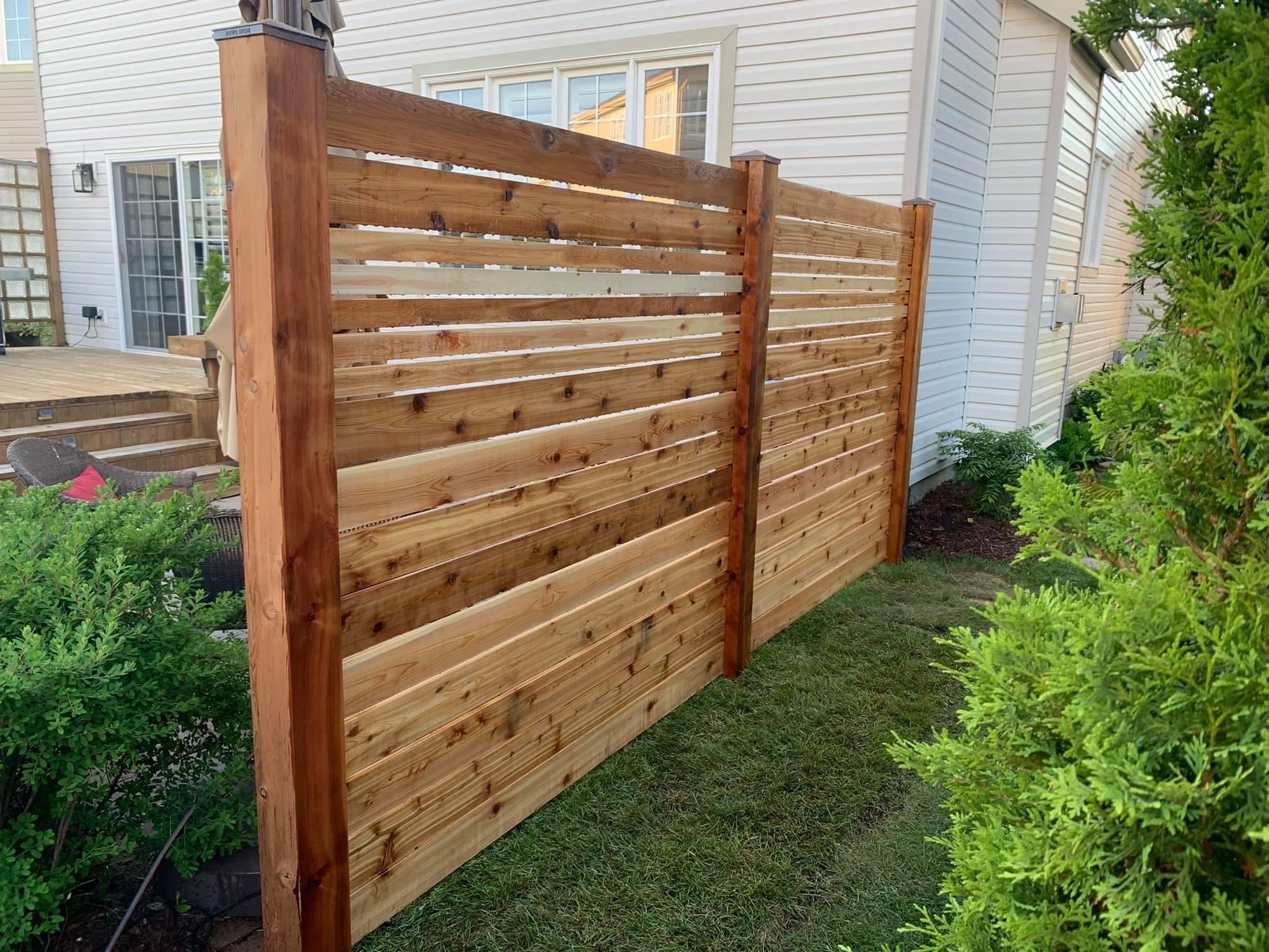 Wooden fence being installed in a back yard.